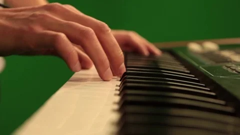 Close-up of hand playing the piano electronic keyboard on green chroma key Stock Footage 81178550
