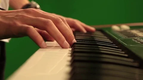 Close-up of hand playing the piano electronic keyboard on green chroma key Stock Footage 81178585