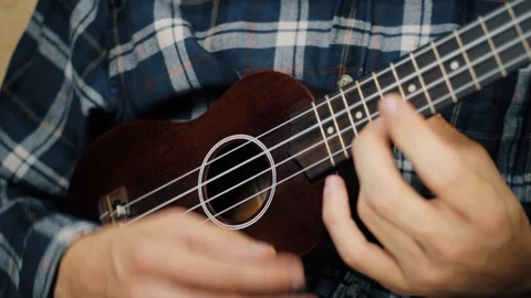 Close up hand playing ukulele. Man touches strings. Wood ukulele Stock Footage 120300218