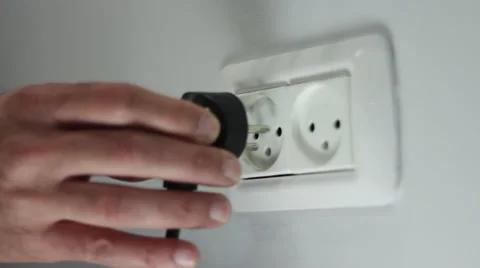 Close up of hand plug-in power cable to socket Stock Footage 35167660