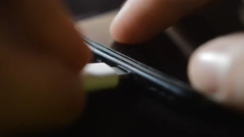 Close-up hand plug a white charging cable to his phone for battery recharge. Stock-Footage 219781094