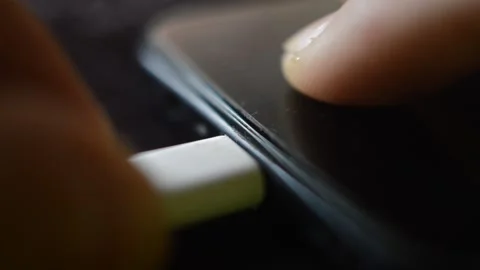 Close-up hand plug a white charging cable to his phone for battery recharge. Stock-Footage 219781104