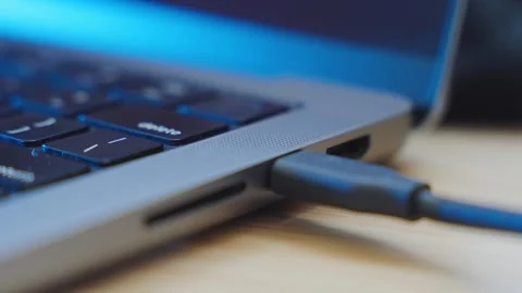 Close up on hand plugging in and plugging out a computer cable to a laptop in Stock Footage 345110614
