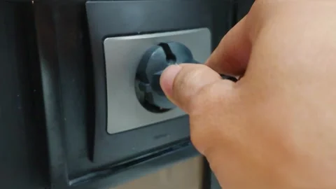 Close Up of Hand plugging a black power plug into an electrical wall socket 動画素材 344093594