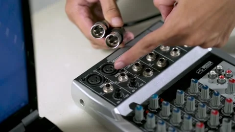 Close-up hand plugging a cable into the audio mixer Stock Footage 156063477