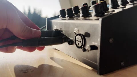 Close-up of a hand plugging a cable into a broadcast intercom audio unit, with Stock Footage 336312337
