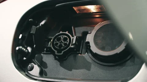 Close up hand plugging in charging cable into electric vehicle Stock Footage 151355742