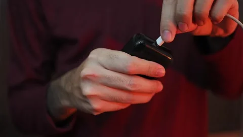 Close Up of Hand Plugging Charging Cable into Electronic Device Stock Footage 337847398