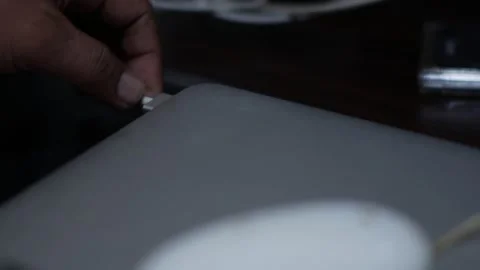 Close Up of Hand Plugging Charging Cable into Laptop Stock Footage 340345020