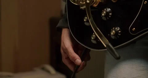 Close-Up of Hand Plugging In Electric Guitar LUT Stock-Footage 323973300
