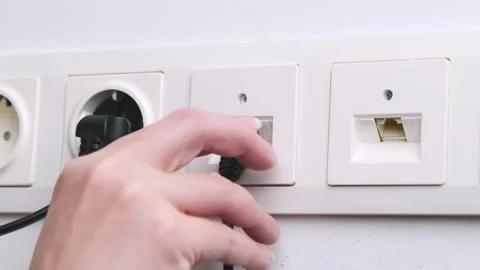 Close-up of Hand Plugging Ethernet Cable into Wall Socket in Modern Indoor .. Stock Footage 309475323