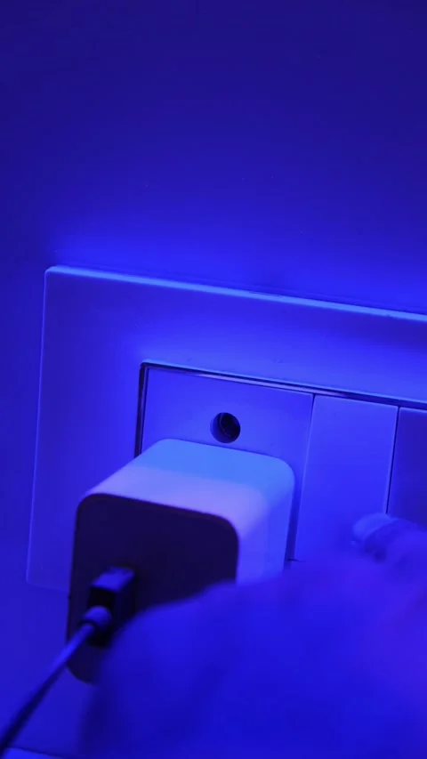 Close up of a hand plugging a power adapter into a wall socket 스톡 동영상 331004370