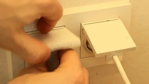 Close up of a hand plugging in a power cord Stock Footage 86414349