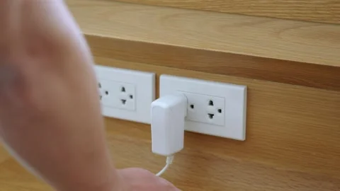 Close up of a hand plugging in a power cord Stock Footage 142849254