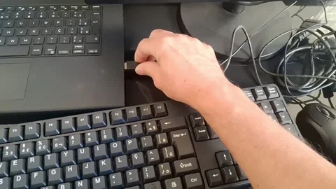 Close-up of a hand plugging a USB drive into a laptop keyboard Stock Footage 340241299