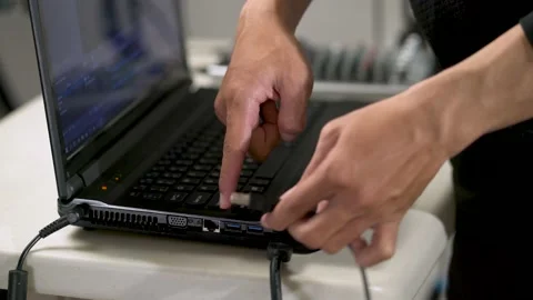 Close-up hand plugs the usb cable into the laptop plug Video stock 156025063