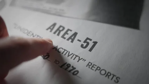 Close up hand pointing on Area 51 report document file folder with UFO activity Stock Footage 334044861
