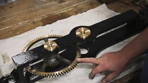 Close-Up of Hand Pointing to Clockwork Gear Mechanism on Workbench 스톡 동영상 345750199