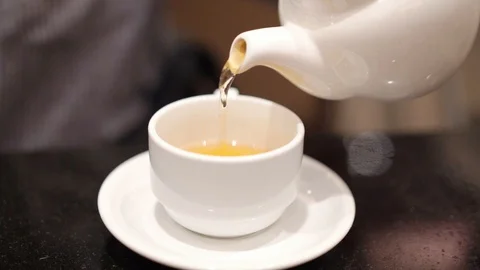 Close up hand pouring hot tea to the cup Stock-Footage 99536235