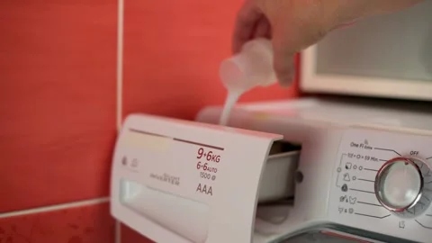 Close-up of hand pouring liquid detergent into detergent compartment of washing Видео 289699492