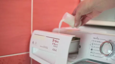 Close-up of a hand pouring liquid detergent into a washing machine dispenser Stock Footage 293492471