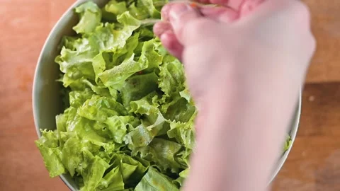 Close-up of hand pouring spices into fresh salad, top view Stock-Footage 338290384