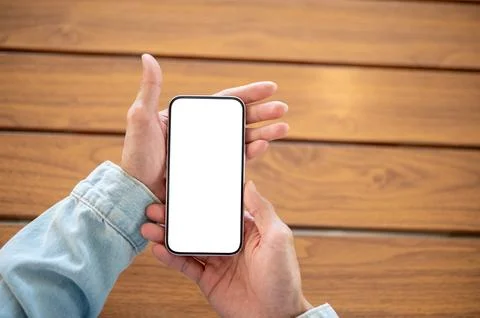 Close up of hand presenting empty screen smartphone over wooden surface for.. Stockfoto's