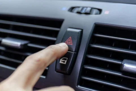 Close up hand press the emergency light in the car, Fingers press button.for  Stock Photos