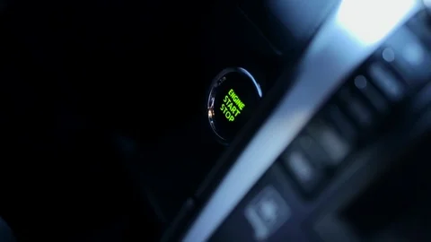 Close up hand presses start button in car.  finger starts the car.  the panel is Stock Footage 129393921