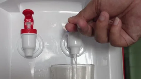 Close up of hand pressing a blue tap on a water dispenser machine to pour fresh  Video stock 337761071