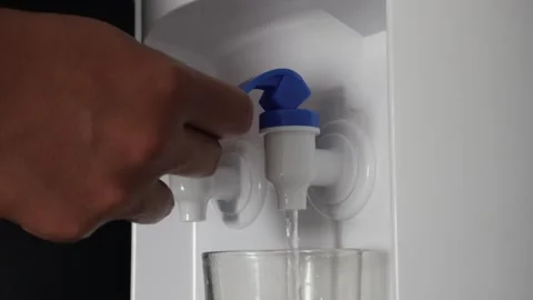 Close up of hand pressing a blue tap on a water dispenser machine to pour fresh Video stock 337761110