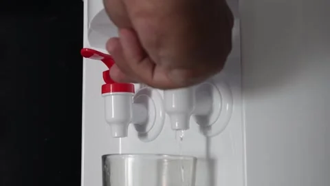 Close up of hand pressing a blue tap on a water dispenser machine to pour fresh  Video stock 337761112