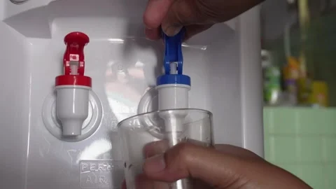 Close up of hand pressing a blue tap on a water dispenser machine to pour fresh  Vídeos de archivo 337761113