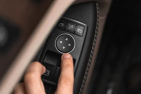 Close-up hand pressing button automatic power controlling window in car. Mode Photos