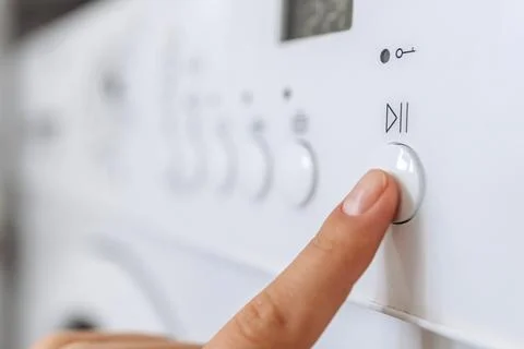 Close-up of a hand pressing a button on a modern washing machine control pa.. Stock Photos