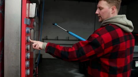 Close up of a hand pressing a button on a self-service coin machine at car wash. Stock Footage 304821953