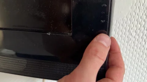 Close up of hand pressing button on television frame, turning on screen, modern 動画素材 337104355