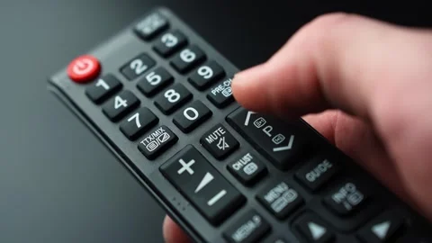Close-up of a hand pressing the channel up or next program button on a TV Stock Footage 332456725