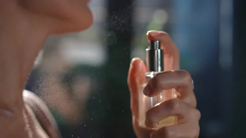 Close-up hand pressing cologne sprayer in slow motion spraying fragrance on Stock Footage 221863771
