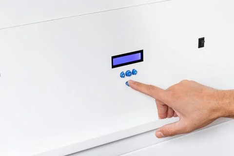 Close-Up of a Hand Pressing Control Panel Buttons with LCD Screen Stock Photos