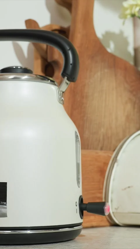 Close up of hand pressing electric kettle button turning it on illuminating red Stock Footage 344419842