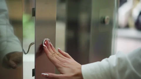 Close-Up Hand Pressing Elevator Button on Sleek Metallic Panel Stock Footage 300105263