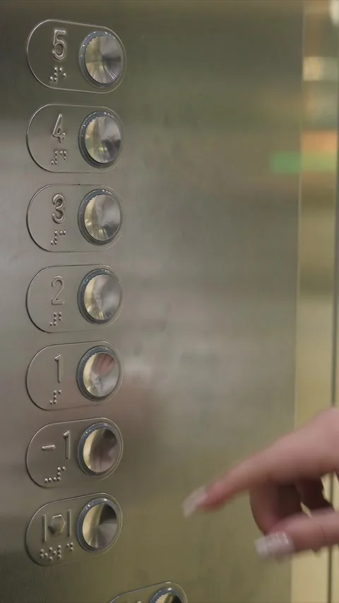 Close up hand pressing elevator buttons with braille and numbers on metal panel Stock Footage 345719850
