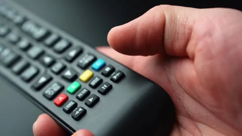 Close-up of a hand pressing the fast forward button on a TV remote, skipping Video stock 329479944