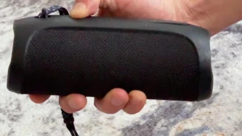 Close up of hand pressing power button on portable speaker, turning device on Stock Footage 337104549