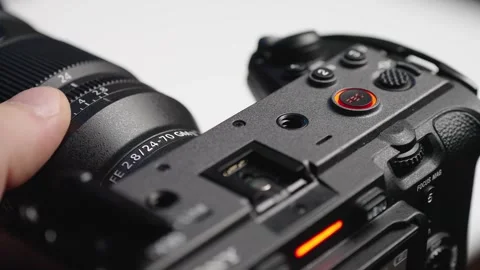 Close-up of hand pressing record button on professional camera with lens at.. Stock Footage 337604640