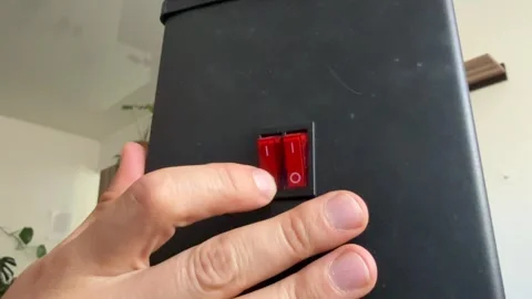 Close up of hand pressing red power button on electric heater. Turning on home Stock Footage 336978679