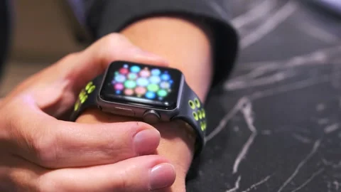 Close-up of a hand pressing a smartwatch button and opening the menu interface Stock Footage 333649416