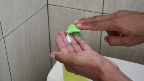 Close up hand pressing soap dispenser pump to release liquid soap, yellow g.. Stock Footage 333377785