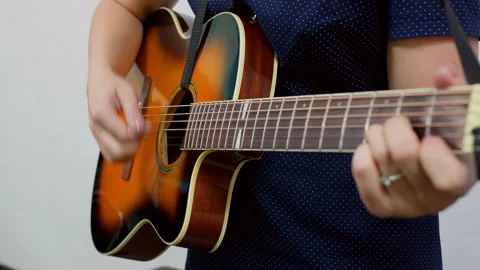 Close up of hand pressing strings on acoustic guitar neck, music focus Stock Footage 317359546